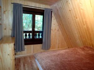 1 dormitorio con cama y ventana en Chata Krpáčovo en Horná Lehota
