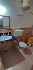 a bathroom with a sink and a toilet and a mirror at Brookefield Service Apartment in Bengaluru +14 photos