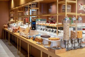 a bakery with a long counter with different types of food at INNSiDE by Meliá Milano Torre GalFa in Milan