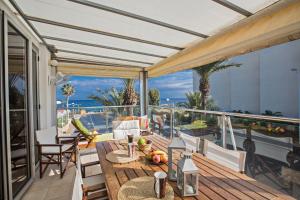 a deck with a table and chairs on a balcony at Pallini Court in Protaras