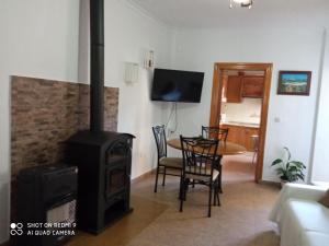 a living room with a wood stove and a table at Apartamentos Virgen de Villaverde in Ardales
