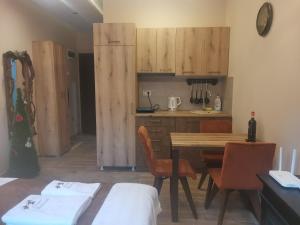 a kitchen with wooden cabinets and a table and chairs at Golden Mountain A75 NLux Milmari in Kopaonik +21 photos