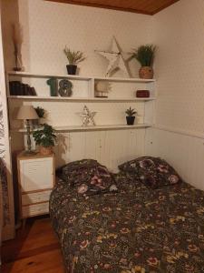 ein Schlafzimmer mit einem Bett und Regalen mit Pflanzen in der Unterkunft Chambre d'hôtes Le Relais de Belloy in Belloy sur Somme