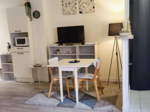 a table and chairs in a room with a tv at Studio Harmony - Zen et Confort - Hypercentre in Troyes