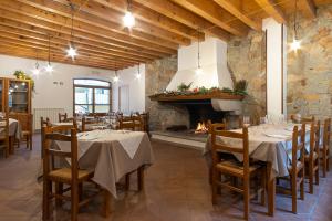 a dining room with tables and a fireplace at Locanda Sighimi in Lanusei