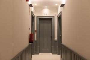 a hallway with grey doors and a red fire extinguisher at FLH Praça Rossio Contemporary Flat in Lisbon