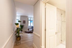a hallway with a door to a room with a plant at FLH Praça Rossio Contemporary Flat in Lisbon