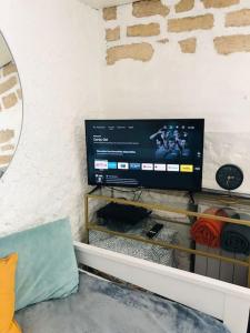 een flatscreen-tv zittend op een tafel bij Cocooning little house in french Vexin in Us