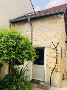 een gebouw met een garage met een slang erop bij Cocooning little house in french Vexin in Us