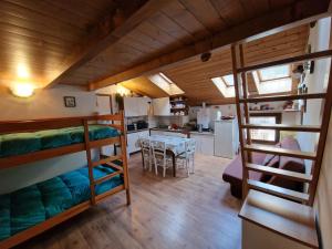 a room with two bunk beds and a kitchen at Appartamento Latemar Predazzo in Predazzo