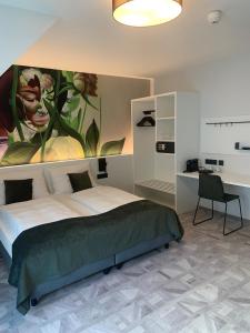 a bedroom with a bed with a painting on the wall at ART-INN Design Self-Check-in-Hotel in Linz