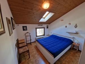 una camera con letto blu e soffitto in legno di Appartamento Latemar Predazzo a Predazzo