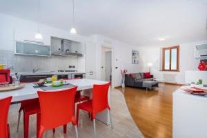 cocina y sala de estar con mesa y sillas rojas en Corte Baldissera Udine Centro, en Udine