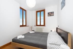 Un dormitorio con una cama grande en una habitación con ventanas. en Corte Baldissera Udine Centro, en Udine