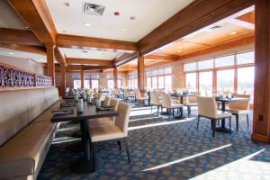 a restaurant with tables and chairs and windows at Skytop Lodge in Skytop