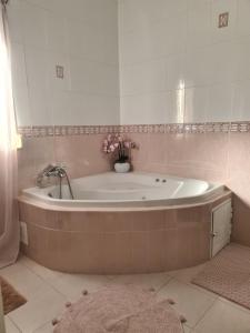 een badkamer met een bad met een vaas met bloemen bij Château Angélique in Valencia