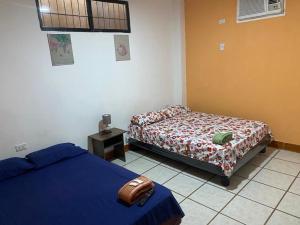 1 dormitorio con 2 camas, mesa y ventana en Dpto en Garzota Norte de Guayaquil 5 mnts aeropuerto, en Guayaquil