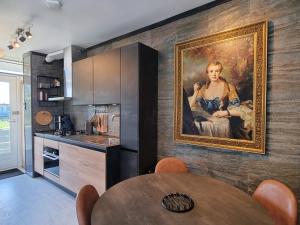 uma cozinha com um quadro de uma mulher na parede em De Schelp 73 the perfect place! em Zandvoort