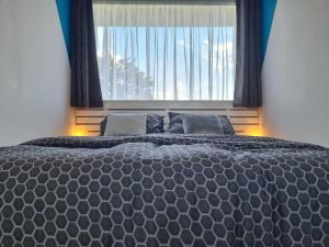 a large bed in a bedroom with a window at De Schelp 73 the perfect place! in Zandvoort