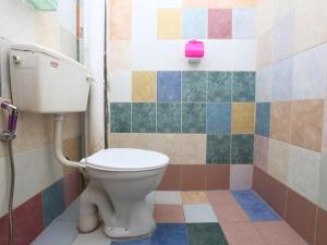 a bathroom with a toilet and colorful tiles at KB Rest Inn-Family Triple in Kota Bharu