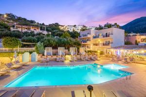 une piscine avec des chaises et un bâtiment dans l'établissement Rainbow Apartments, à Stalida