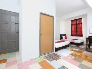 a room with a door and a bed and a couch at KB Rest Inn-Family Triple in Kota Bharu