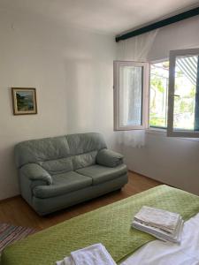 a living room with a green couch and a window at A big apartment for a big holiday! in Sumpetar