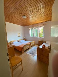 a bedroom with two beds and a wooden ceiling at A big apartment for a big holiday! in Sumpetar