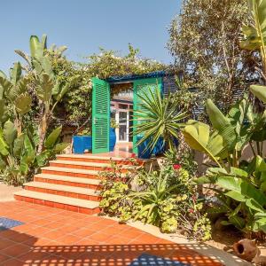 une maison avec des volets verts et des escaliers dans un jardin dans l'établissement Mimid Dunes Beach, à Mirleft
