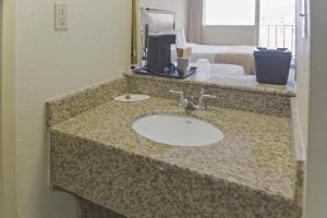 a bathroom with a sink in a hotel room at Economy Hotel Plus Wichita in Wichita