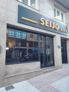 a store with a sign on the side of a building at Seijo in Villalba