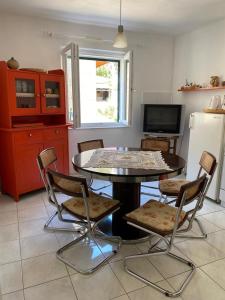 a kitchen with a table and chairs and a refrigerator at A big apartment for a big holiday! in Sumpetar