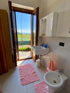 ein Bad mit einem Waschbecken, einem WC und einem Fenster in der Unterkunft Cascina la Barona in Savigliano