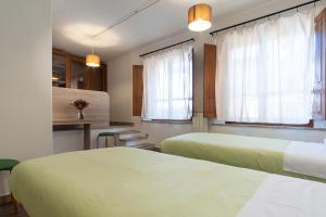 a hotel room with two beds and a kitchen at Locanda Sighimi in Lanusei