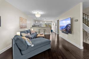 sala de estar con sofá gris y cocina en Beautiful & Cozy DT Home With PingPong Table en San Juan de Terranova
