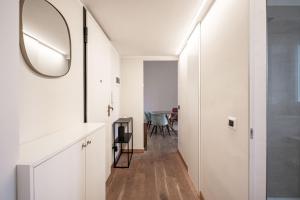 pasillo blanco con espejo y mesa en Montello Livings, Exclusive terrace and skyline view, en Milán