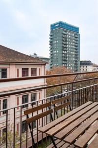 a wooden bench sitting on top of a balcony at Montello Livings, Exclusive terrace and skyline view in Milan