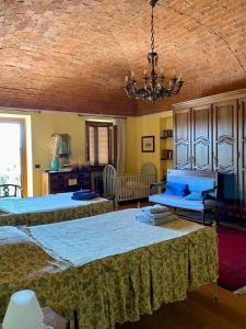 1 dormitorio con 2 camas y lámpara de araña en Cascina la Barona en Savigliano
