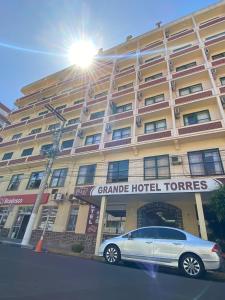 um carro estacionado em frente a um grande hotel em Grande Hotel Torres em Torres