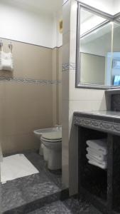 a bathroom with a sink and a toilet and a mirror at Buenos Aires Apart in Salta