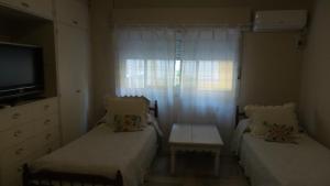 a small bedroom with two beds and a window at Buenos Aires Apart in Salta