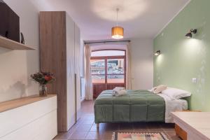 una camera con letto verde e finestra di Locanda Sighimi a Lanusei