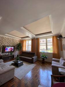 ein Wohnzimmer mit einem Sofa und einem TV in der Unterkunft Grande Hotel Torres in Torres