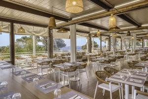un restaurant avec des tables, des chaises et des fenêtres dans l'établissement Belambra Clubs Presqu'île De Giens - les Criques, à Hyères