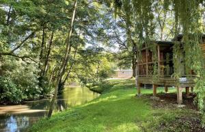 a tree house sitting on the side of a river at Huttopia Les Châteaux in Bracieux