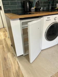 a white washer and dryer under a kitchen counter at Studio calme & lumineux, vue sur le jardin, WIFI in Paris