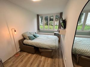 - une petite chambre avec un lit et un miroir dans l'établissement Studio calme & lumineux, vue sur le jardin, WIFI, à Paris