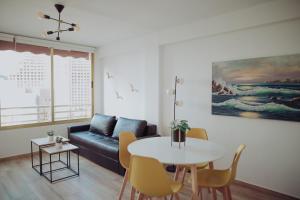 uma sala de estar com um sofá e uma mesa em Bonito apartamento con piscina. em Benidorm