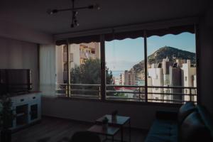 uma sala de estar com uma grande janela com vista para a cidade em Bonito apartamento con piscina. em Benidorm