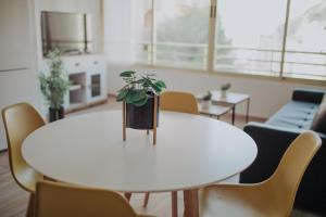 uma mesa branca com uma planta em vasos em Bonito apartamento con piscina. em Benidorm